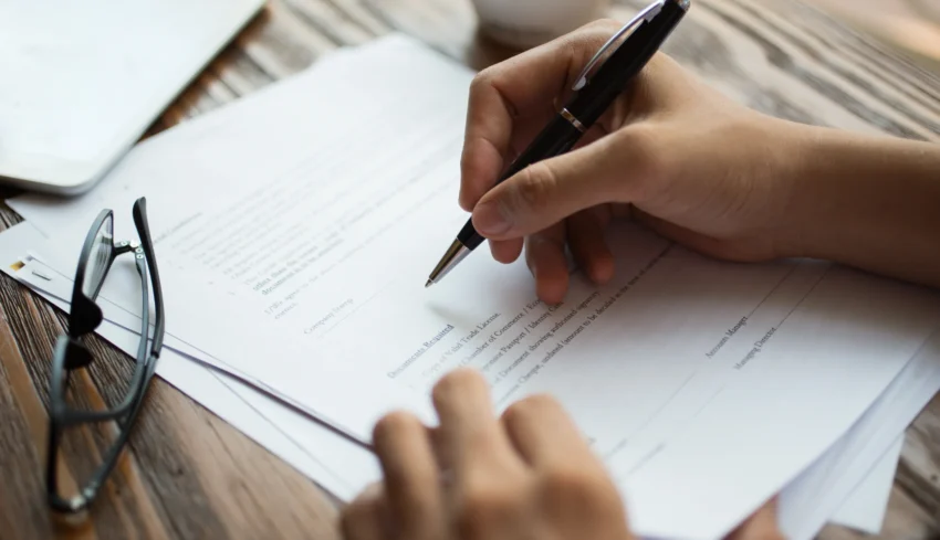 businessman-examining-papers-table